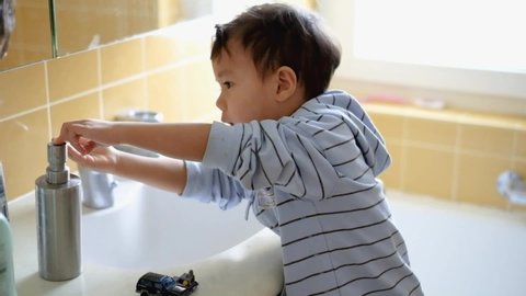 Cute little boy washing his hands with a hand wash gel in sink. Clean hand concept idea. Health care Coronavirus, Covid-19  protection.