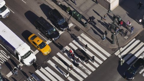 NEW YORK CITY - NOVEMBER 2016: Long shot of intersection with pedestrian crossing the streets and vehicle traffic on 34th Street and 5th Avenue in New York City, USA