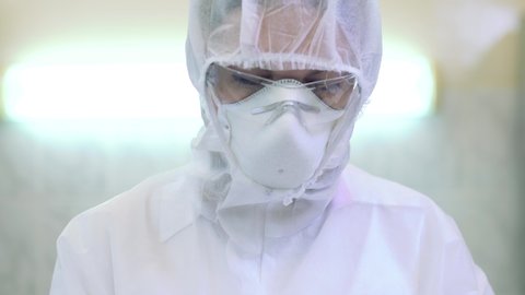 Scientists in protective suits in a science laboratory study a dangerous virus to eliminate the epidemic. Video Stok