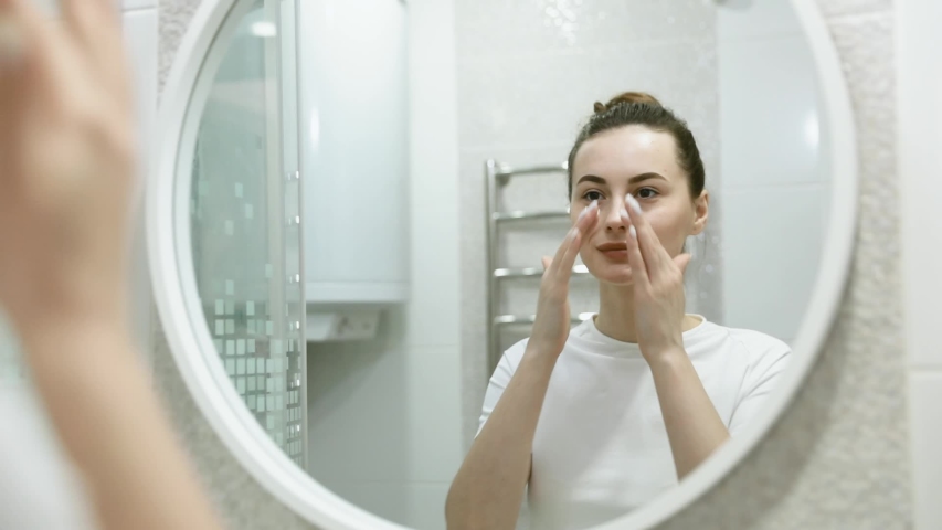 Young and healthy girl washing her face with face cleanser than clearing the foam with a sponge | Shutterstock HD Video #1046258437
