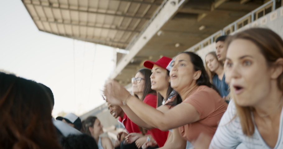 Crowd of sports fans cheering during a match in stadium. Group of friends watching sports game celebrating when their team scoring a goal. Royalty-Free Stock Footage #1046269015