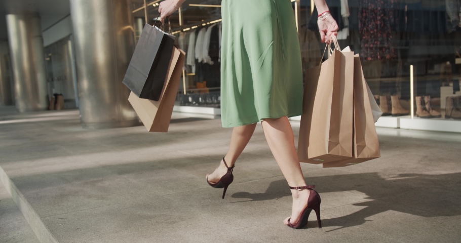 attractive happy girl walks with shopping bags