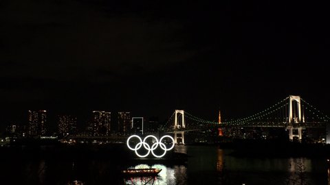 TOKYO, JAPAN - FEB 2020 : The five ring symbol of the Olympic Games in front of Odaiba Rainbow Bridge. Japan will host the Tokyo 2020 summer Olympic and Paralympic. Shot in night light up time.