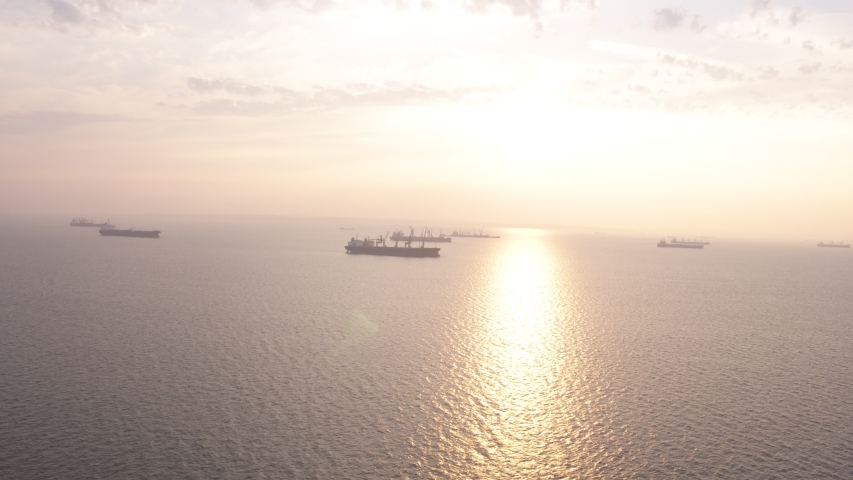 Flight over Blak sea and ships in port Taman during sunset