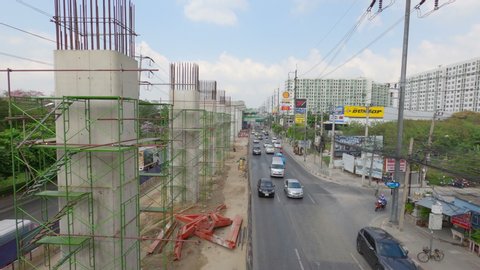 BANGKOK, THAILAND - February 6, 2020 : BTS Sky Train Construction on the Ramintra road in Bangkok. This Sky Train is Pink Line. Construction in the midst of traffic. 4K 30FPS.
