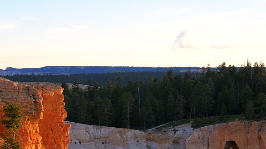 High angle view from overlook point of hoodoos rock formations in Bryce Canyon National Park at sunset with sunlight sun panning