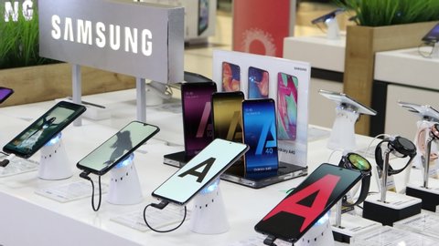 Belgrade, Serbia - February 11, 2020: Samsung Galaxy A71 mobile smartphone is shown with A51, A40, A30s and smartwatches on retail display in electronic store. Brand logo in the background.