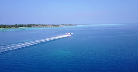 Seaplane take off from the ocean lagoon, in front of a luxury resort in Maldives