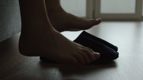 Silhouette of male legs slips a slippers