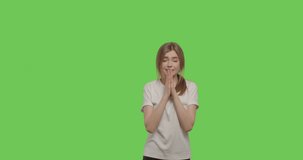 worried girl fold hands together and pray for good luck and wins isolated over green background. Young woman rejoice in winning lottery or exam on chroma key. 4k raw video footage slow motion 60 fps