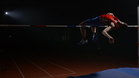 The man successfully performed a high jump over the bar. Slow motion