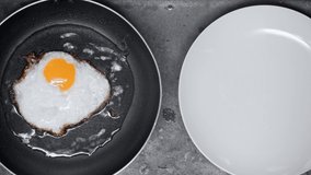 fried egg on frying pan near plate