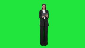 Serious busy young business woman using tablet computer interacting with touch screen. Full length on green screen background. - Powered by Shutterstock - Get 15% off with code: PIKWIZARD15