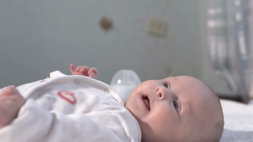 Happy baby girl lying on the bed. The concept of motherhood