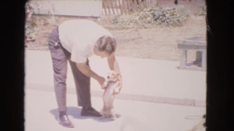 BARSTOW CALIFORNIA USA-1966: Older Man Trying His Hardest To Teach Young Dog New Tricks