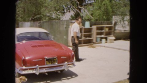 BARSTOW CALIFORNIA USA-1966: Man Closing Vintage Car And Walking Away With His Dog