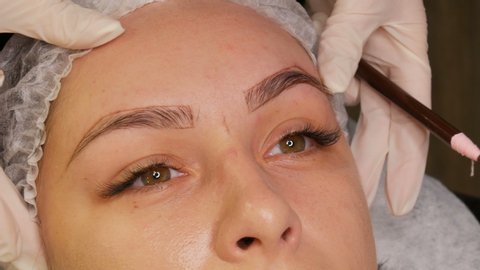 The eyebrow shape correction master applies a special dark pigment under the skin to emphasize the density of the eyebrows. Modern cosmetic procedures, eyebrow microblading, permanent makeup, tattoo.
