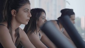 A movement shot of group of attractive youngsters training on stationary exercise bike. Male and female gym enthusiasts working out on stationary bicycles during cardio work out in a fitness studio. - Powered by Shutterstock - Get 15% off with code: PIKWIZARD15