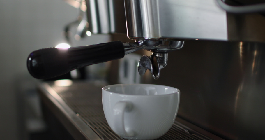 Making a cup of strong coffee in a coffee machine, the back light illuminates the steam and the cup. Royalty-Free Stock Footage #1046431882