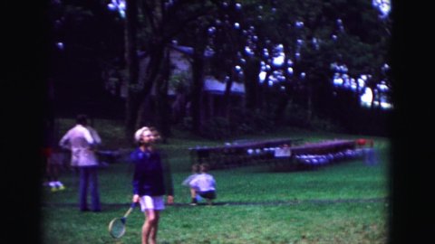 GALENA ILLINOIS USA-1967: People Playing Badminton On Sunny Day In Park Setting She Swings And Misses Shuttlecock