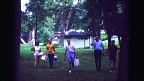 GALENA ILLINOIS USA-1967: Men And Women Carrying Lunch Boxes Walk Toward A Campsite