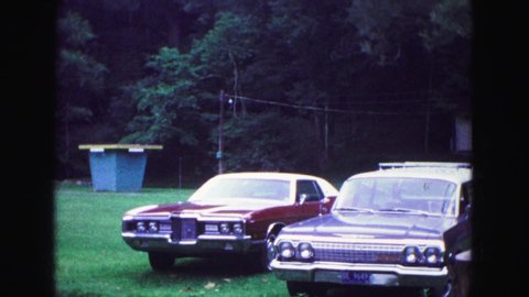 GALENA ILLINOIS USA-1967: Two Fancy Red American Muscle Cars Are Parked In A Field While People Set Up Camp