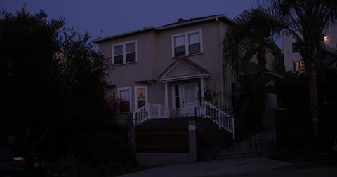 An upscale house exterior, establishing shot with a locked off angle at night. Affluent neighborhood with palms trees in Los Angeles or San Diego California. Native 10bit 422 prores 