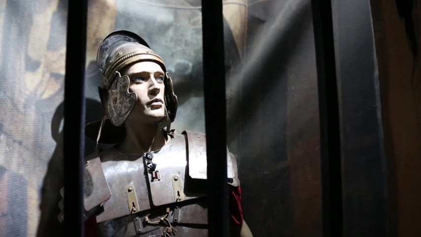 Mannequin clad in traditional medieval armor, adorned with an ancient iron Greek helmet and a striking Gladiator cape. The portrait captures the essence of an Ancient Warrior, a Greek hero 