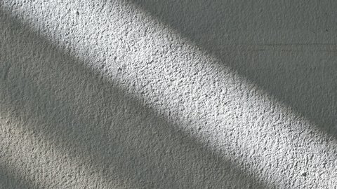 Time lapse sunrise drop shadow on old white concrete wall. 