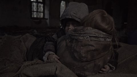 Homeless children hug each other in support of the ruins. Apocalypse. War.
