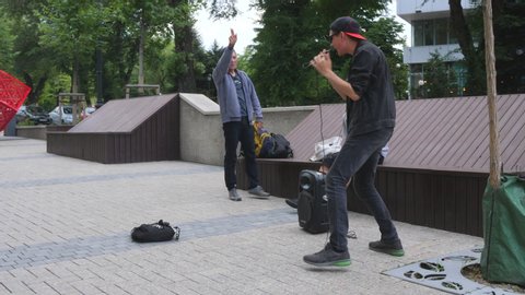 Almaty, Kazakhstan - June 14, 2019: Street beatboxer musicians sing at the walking street at summer. Young people making street art.