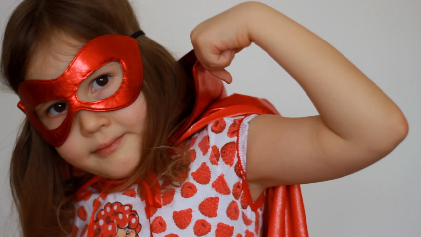 Cute baby girl plays superhero. Funny child in a red raincoat and mask playing power super hero. Superhero and power concept. Portrait close up Royalty-Free Stock Footage #1046464234