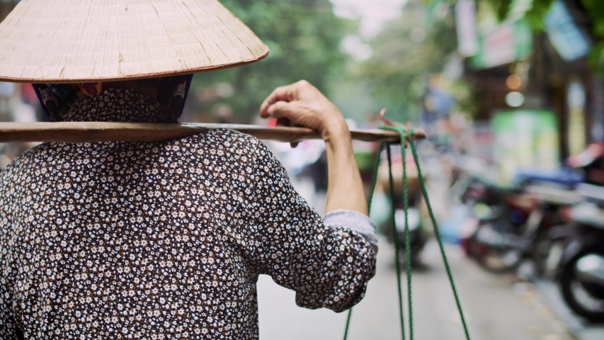 Handheld view of Vietnamese woman walking in the street. Shot with RED helium camera in 8K