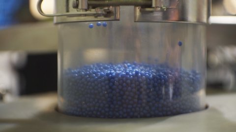 Processing of polymeric materials. Moving blue granules in production. Technological progress.