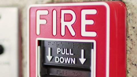 Rack focus of fire alarm button in modern office building