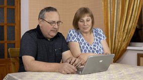 A man and a woman communicate with friends via video communication via a laptop. A young girl approached her parents and also began to communicate. The family is sitting in a comfortable room.