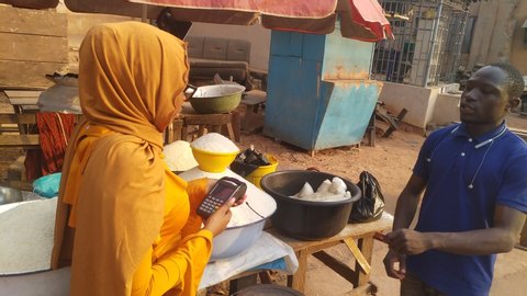 african woman in a local african market using a mobile point of sale device