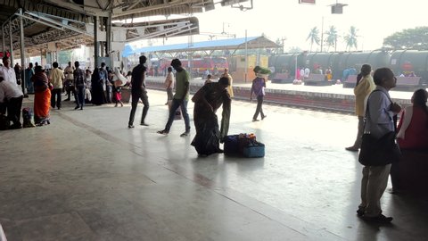Samalkot , Andhra Pradesh / India - 11 04 2019: Indian Railways passenger train arrives Samalkot Station, East Godavari, Andhra Pradesh as food vendor crosses the tracks to board the arriving train