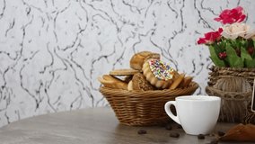 Coffee cup with candies and cookies with flowers on spinning wooden table background. FHD.