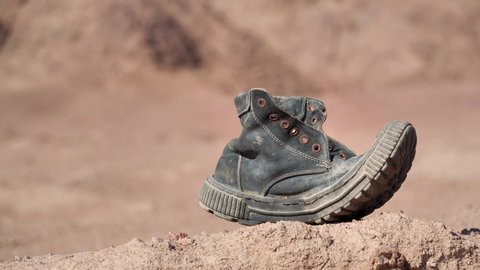 Old black boot in desert