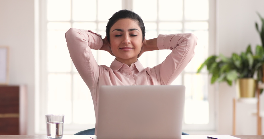 Young indian business woman worker relax sit at office desk finished laptop computer work put hands behind head feel satisfied with work well done stress relief peace of mind concept chill at work Royalty-Free Stock Footage #1046584750