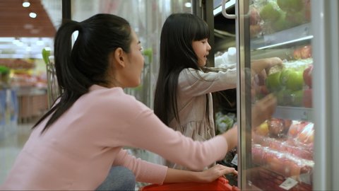 Shopping concepts. The daughter is buying fruit for her mother in the mall. 4k Resolution.