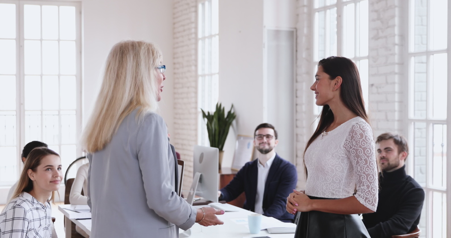 Happy young best female worker trainee intern being appreciated promoted handshake older executive, mature boss praising rewarding thanking millennial employee express respect and recognition concept Royalty-Free Stock Footage #1046587786
