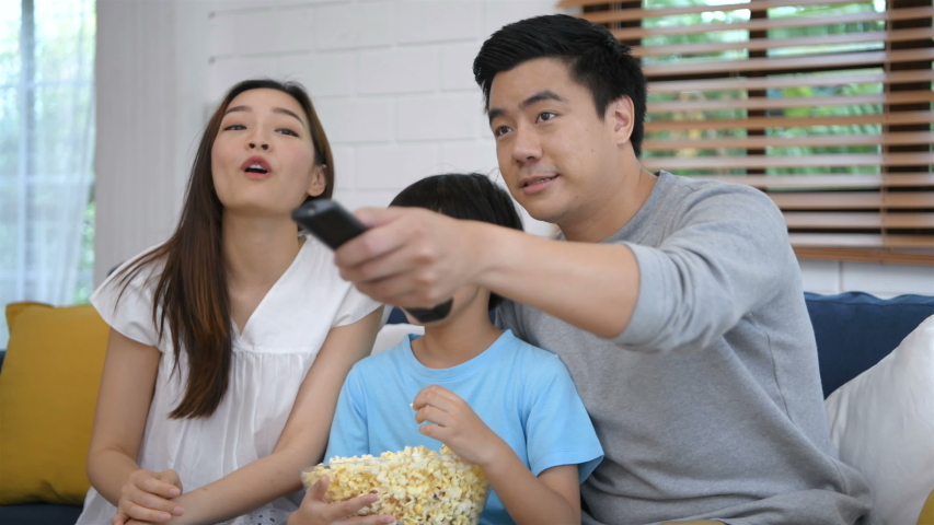 Family concept. The family is watching tv cheerfully. 4k Resolution.