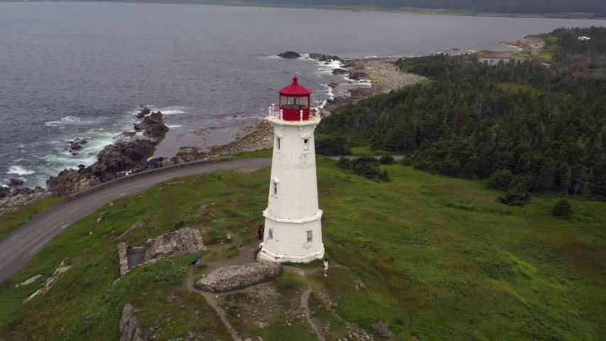 Aerial Drone view of Louisbourg Lighthouse in Cape Breton Island, Nova Scotia, Canada. The drone is rotating around the lighthouse. Lighthouse Point is the site of the first lighthouse in Canada.