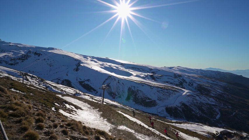 Panorama of Ski resort of Sierra Nevada in winter, full of snow, with unrecognizable man doing cross-country skiing under bright sun