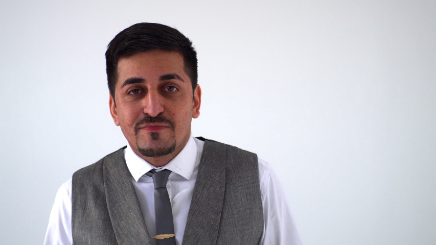 The Eastern man exults, shakes his hands above his head, and smiles broadly