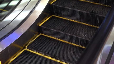 An empty escalator with stairs goes up. Lower escalator steps
