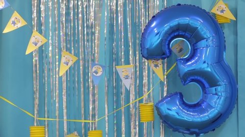 Kyiv, Ukraine - 10 02 2019: Three years birthday balloon on children minions style happy birthday party yellow blue colors design decorations background