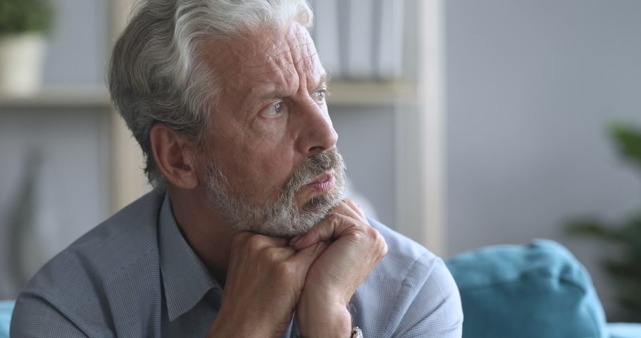 Head shot worried older mature man sitting on couch, suffering from depression psychological problem alone at home. Frustrated grandpa trying remembering important information, dementia disease. Royalty-Free Stock Footage #1046611714
